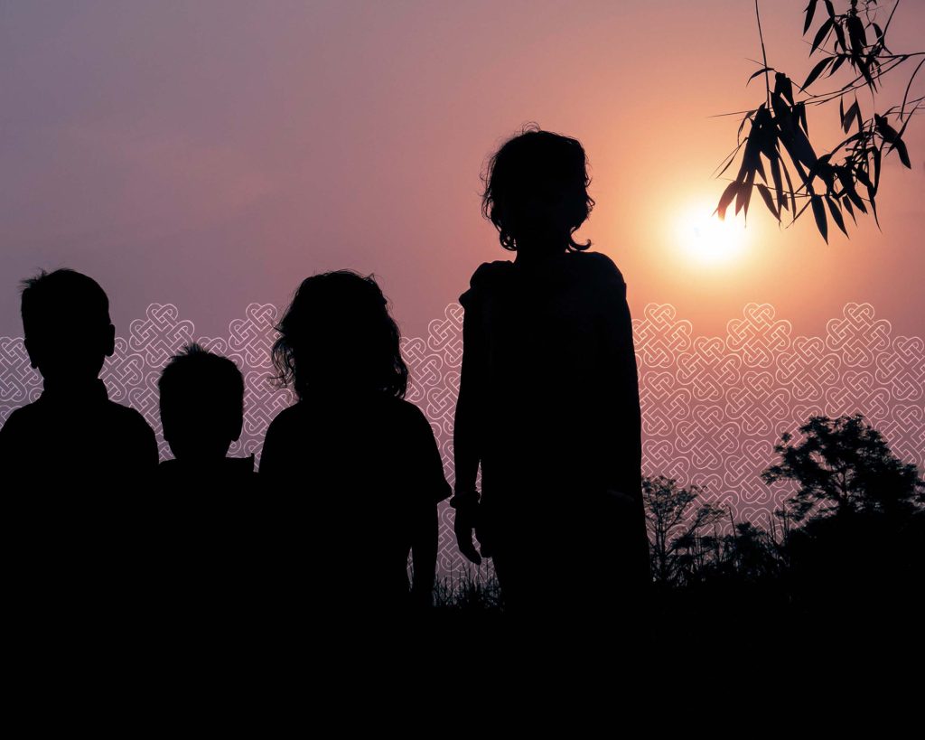 silhouettes of children staring into the sunset